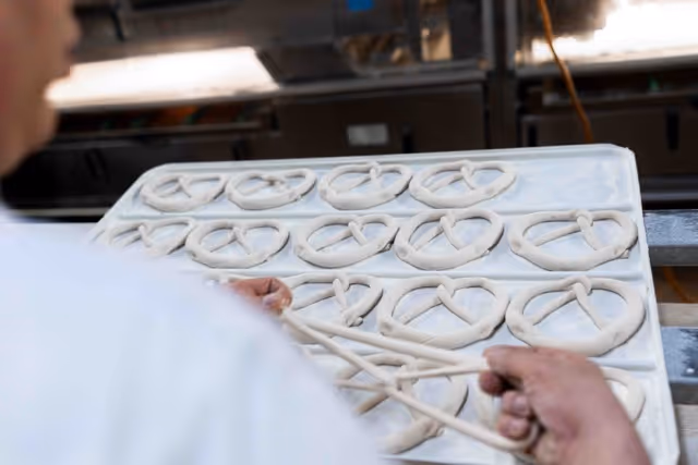Brezel wird geknotet und auf das Blech gelegt